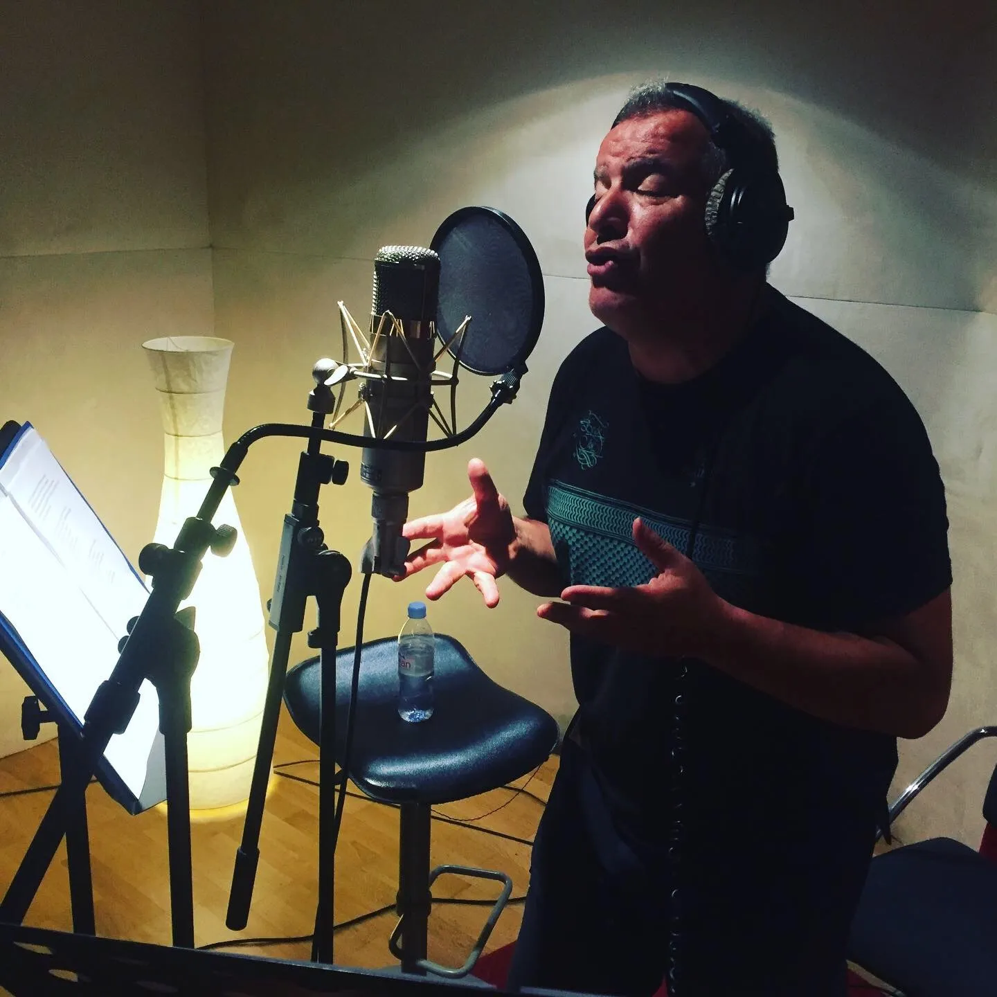 Chanteur au micro en cabine, casque sur les oreilles