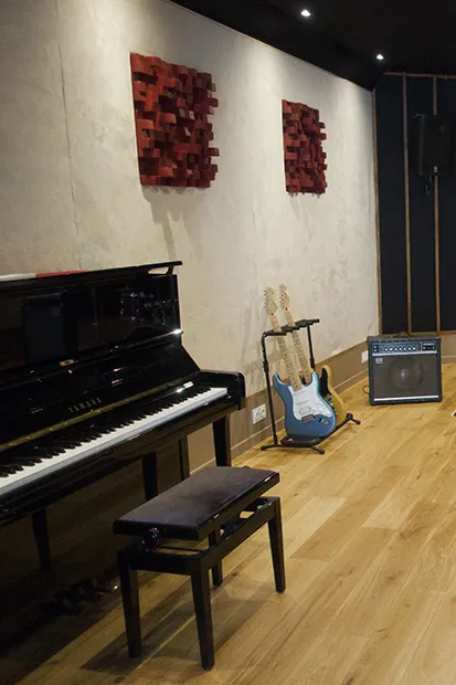 Salle de répétition : piano droit, guitare et ampli